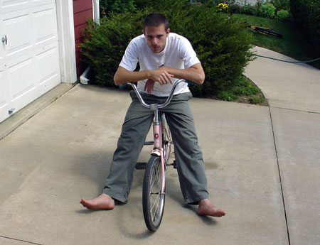 Brandon sitting on a pink bike